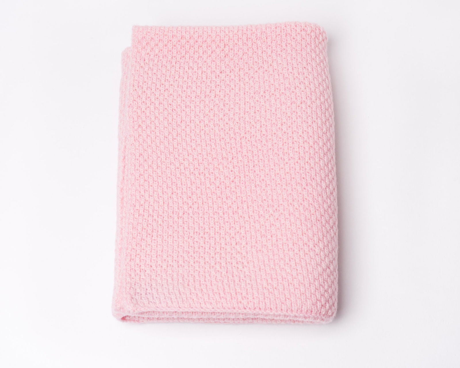 Nivas Cashmere Blend Baby Blanket, folded in pink on a light background, crafted with luxurious wool.