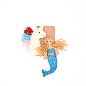 The Nivas Mermaid & Unicorn Finger Puppet Set includes colorful felt figures like a white felted unicorn and a mermaid with a blue tail and orange hair, ideal for imaginative play. Attach to the brown card for endless storytelling fun.