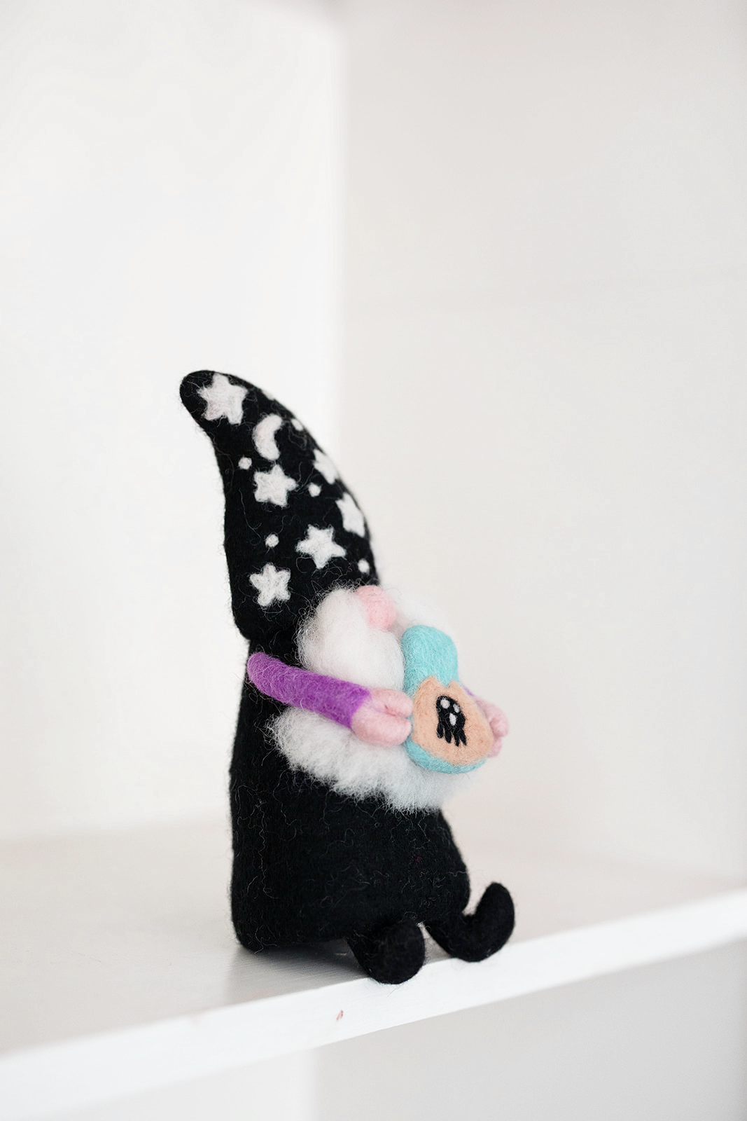 The Nivas Halloween Gnome - Wizard features a star-patterned hat and holds a colorful cartoon-eyed object, making it a charming addition to your whimsical Halloween décor.