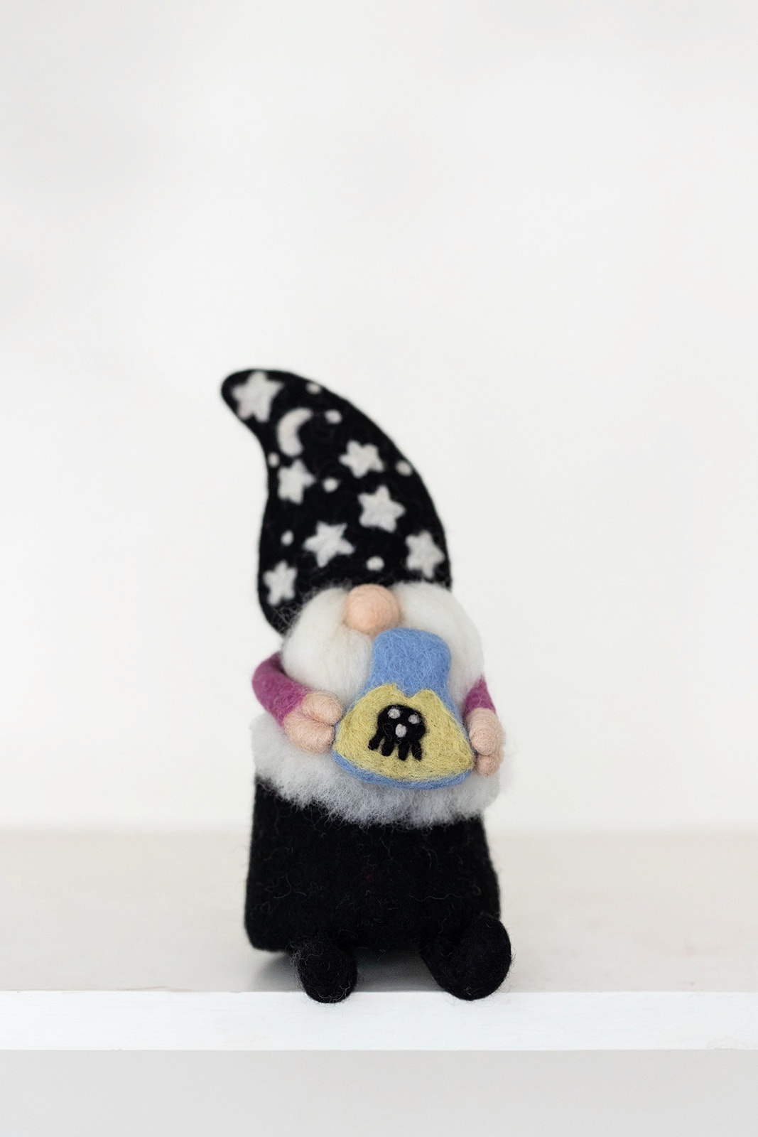 The Nivas Halloween Gnome - Wizard features a handmade design with a star and moon hat, holding a heart-shaped object adorned with a bee—perfect whimsical décor for Halloween.